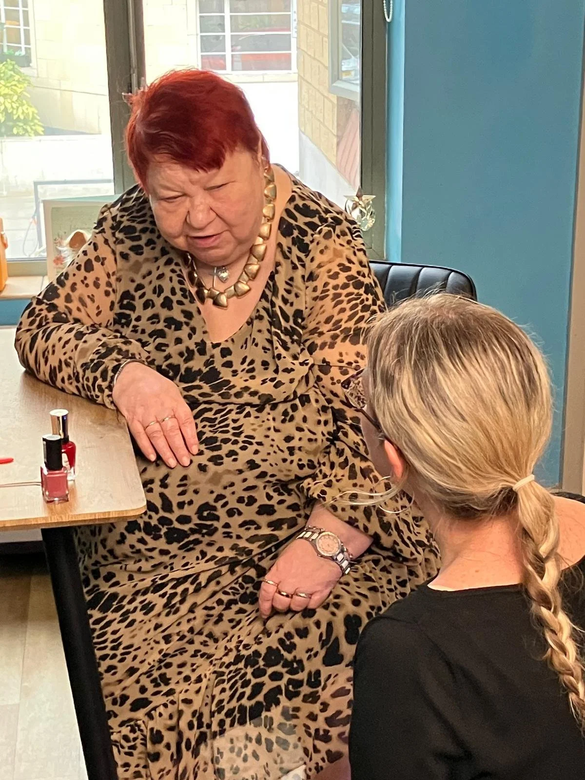 A care home resident is having her finger nails painted by a carer who is engaged and understands her needs thanks to watching a Life Story Film