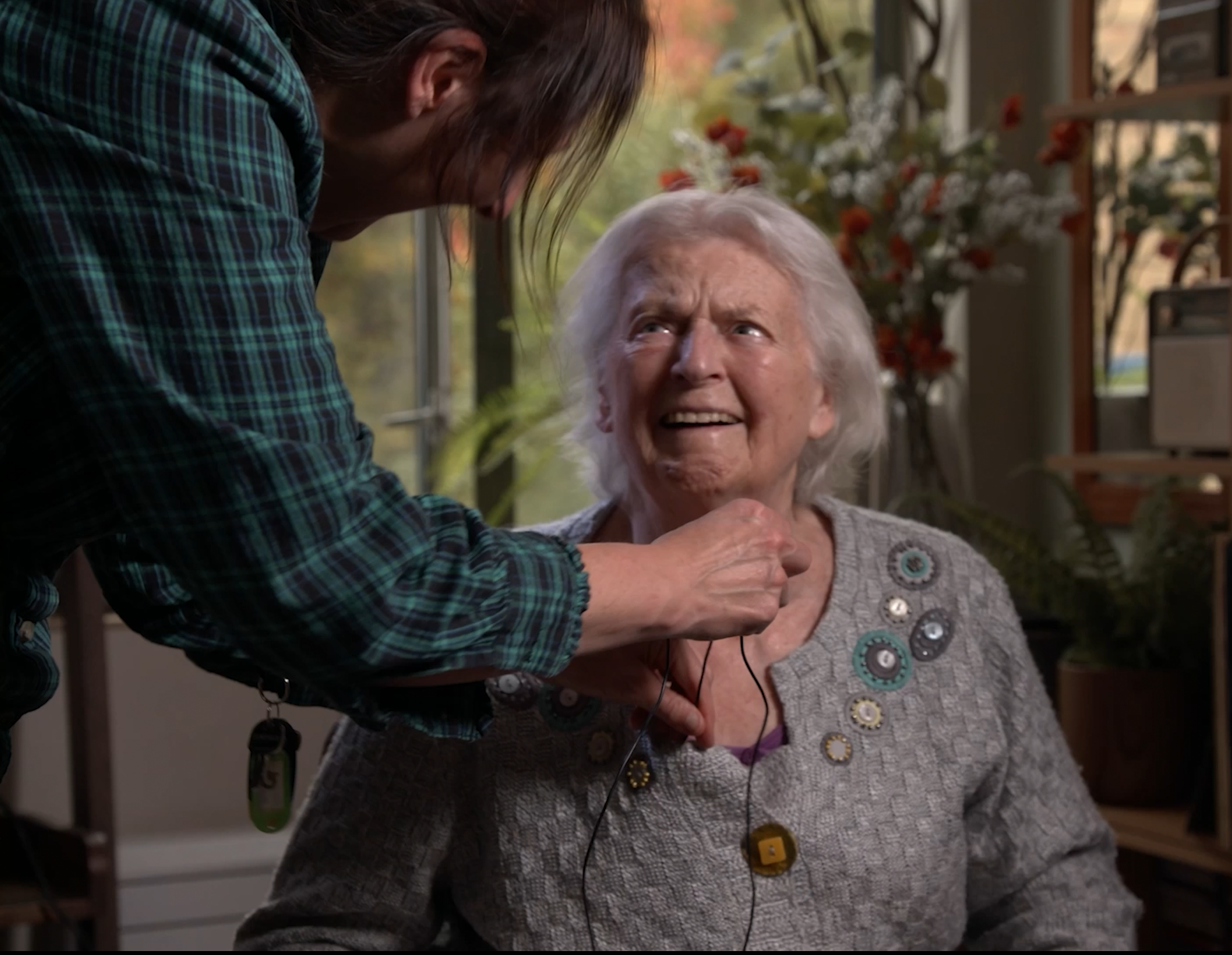 Gently taking the mic off an elderly resident after filming.  She is happy because it's been such a fun, enriching experience for her and made her feel young and improved her memory