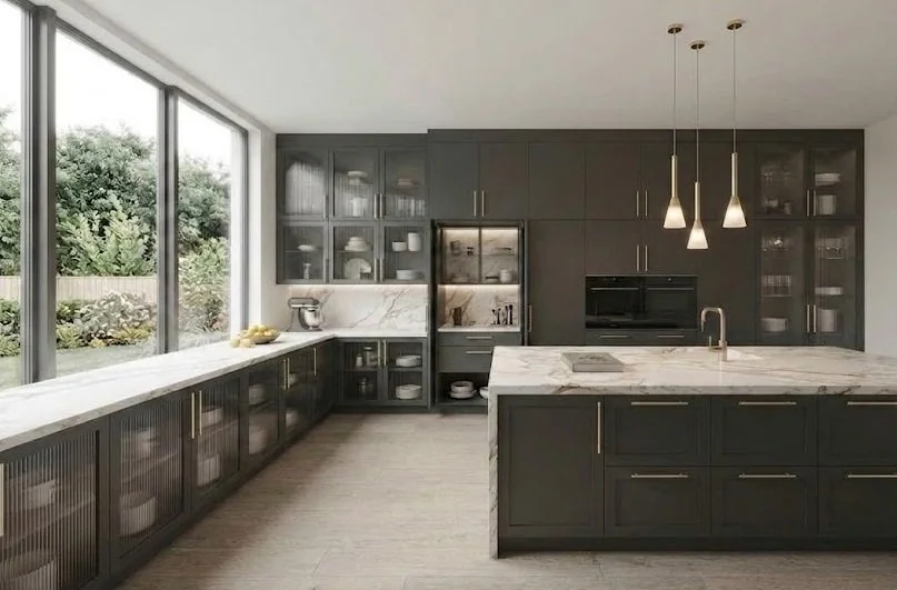 Modern kitchen remodel showcasing the trend of glass cabinet doors, featuring dark cabinetry with illuminated glass uppers, a white marble island, and modern pendant lighting