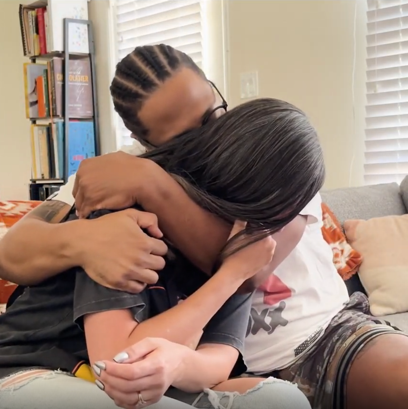 a husband and wife hugging during a mournful moment. She is crying and he is comforting her, you cannot see their faces
