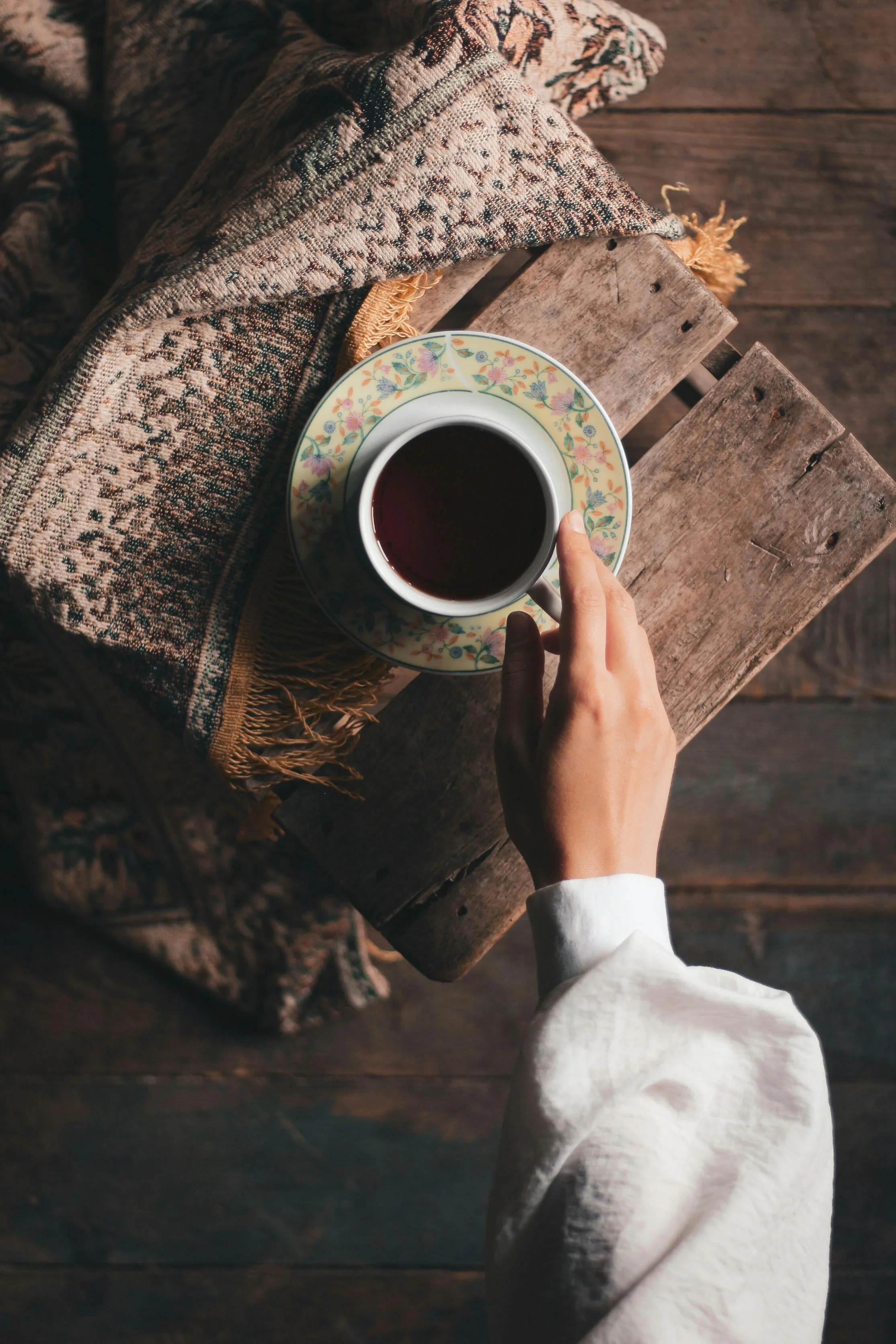 person with tea and journalling
