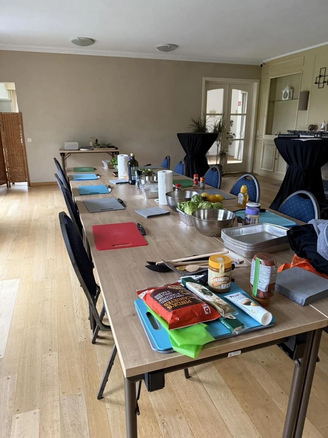 Une grande table en bois avec divers aliments et ustensiles de cuisine pour teambuilding cuisine