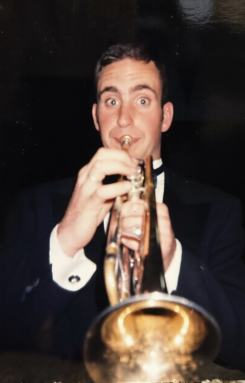 A man in a tuxedo playing a trumpet.