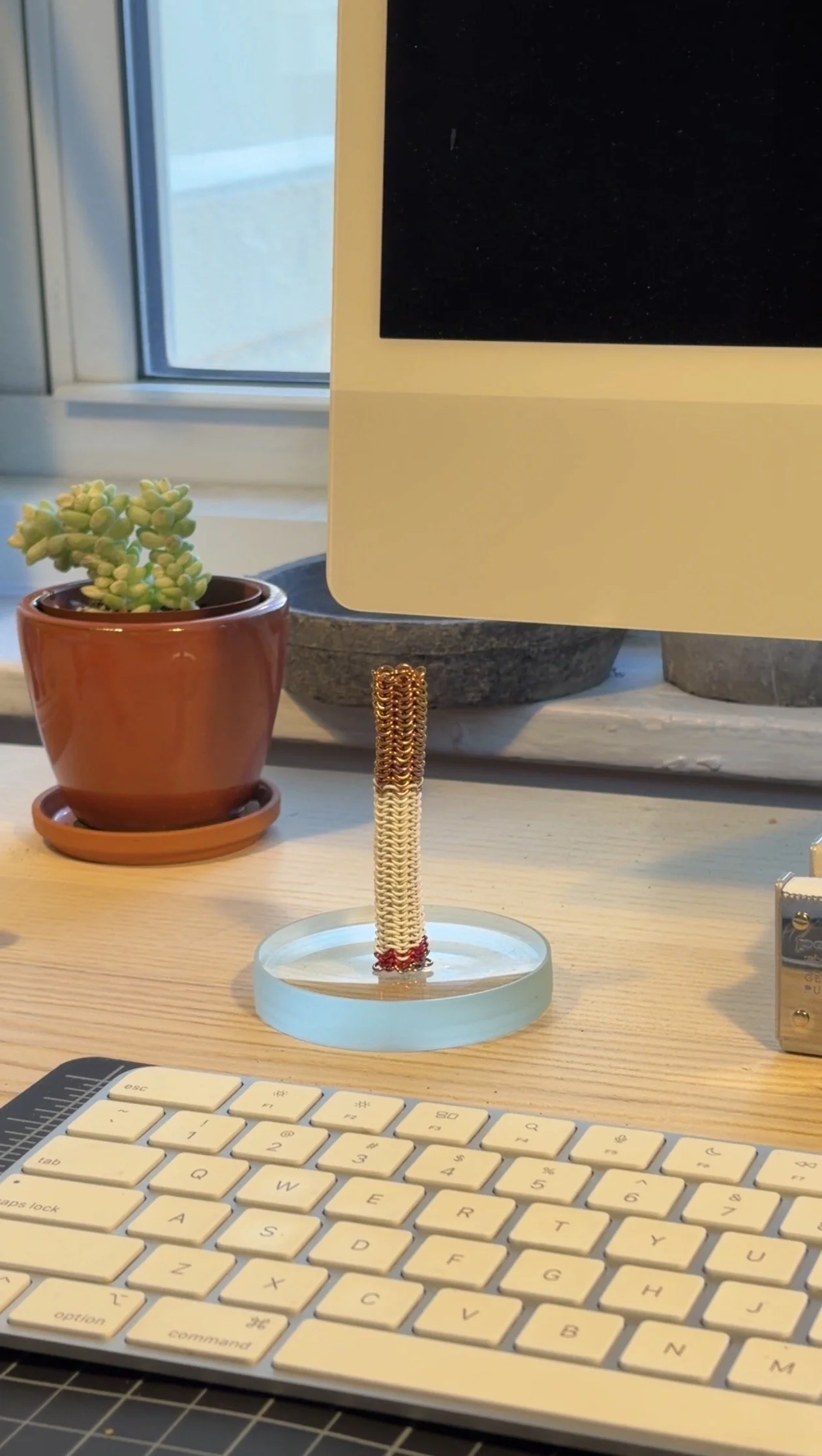 Eternal Cigarette metal sculpture displayed upright on desk beside plant and monitor, small collectible art object by Litor Studio.