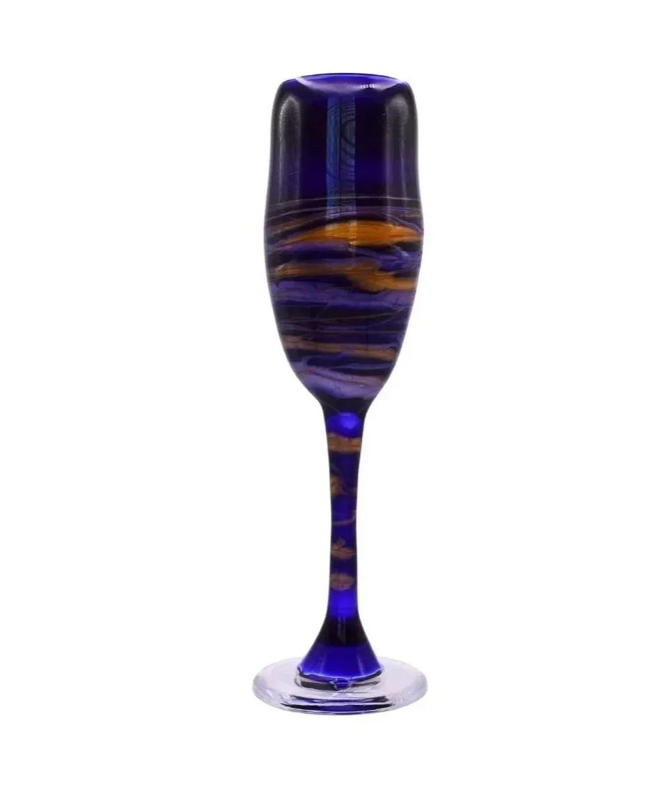 Hand spun custom champagne flute with purple and orange swirls on a white background.