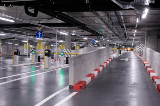 Underground parking garage with parking barriers and directional signs.