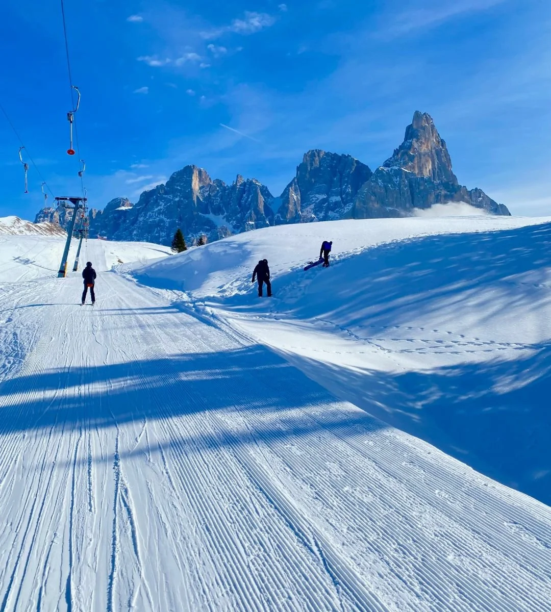 A red helicopter flying over a snowy mountain landscape