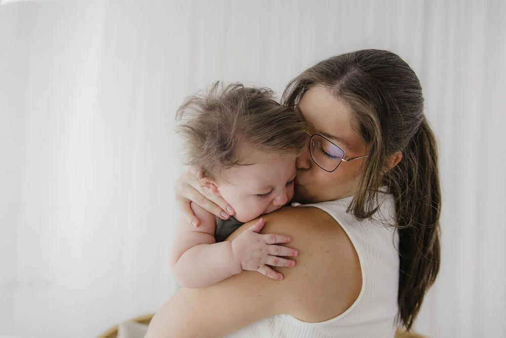 A woman holding a crying toddler in her arms.