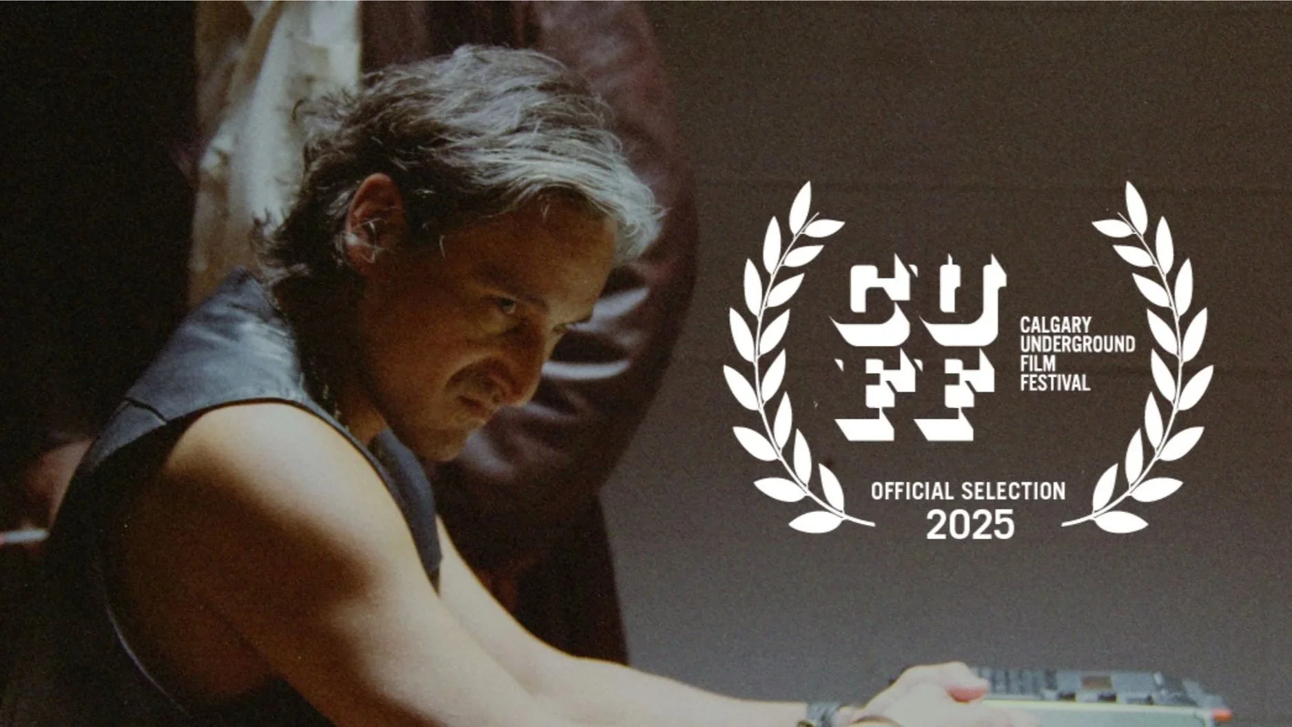 Scene from Renegade Fever showing a person with a serious expression, sitting at a table in a dimly lit room. Superimposed on the right is a logo for the Calgary Underground Film Festival with laurel wreaths, indicating official selection in 2025.