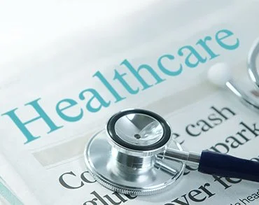 A stethoscope placed on a newspaper with the headline 'Healthcare'