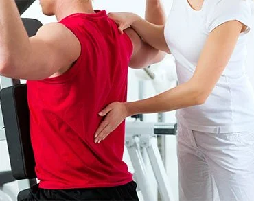 Physical therapist assisting a patient with shoulder pain.