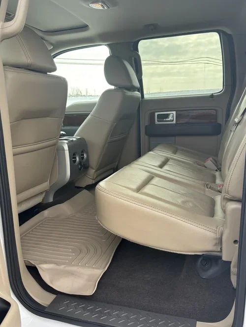 Interior of the truck, featuring tan leather seats, and tan all-weather floor mats