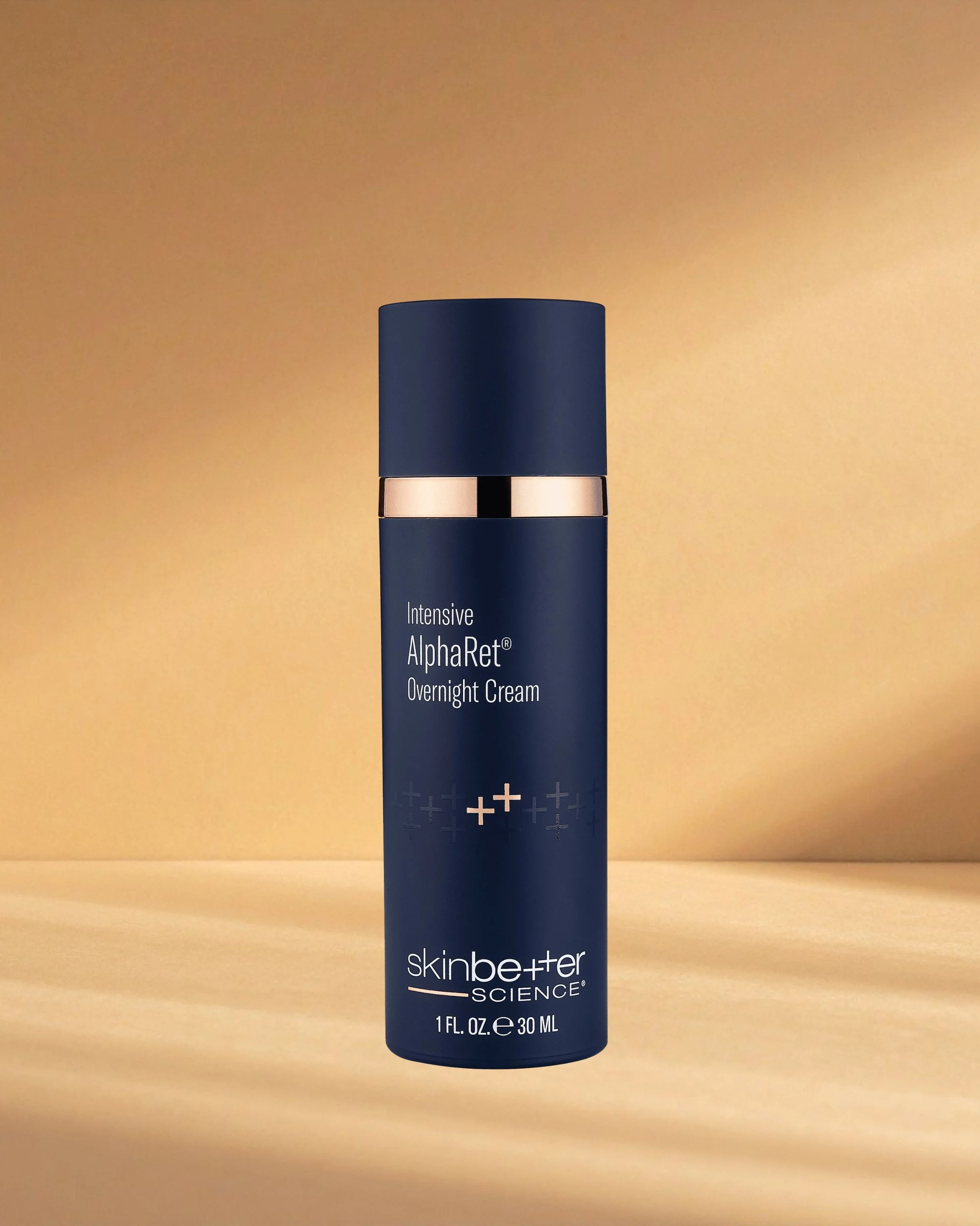 A blue bottle of SkinBetter Science Intensive AlphaRet Overnight Cream on a wooden surface with a beige background.