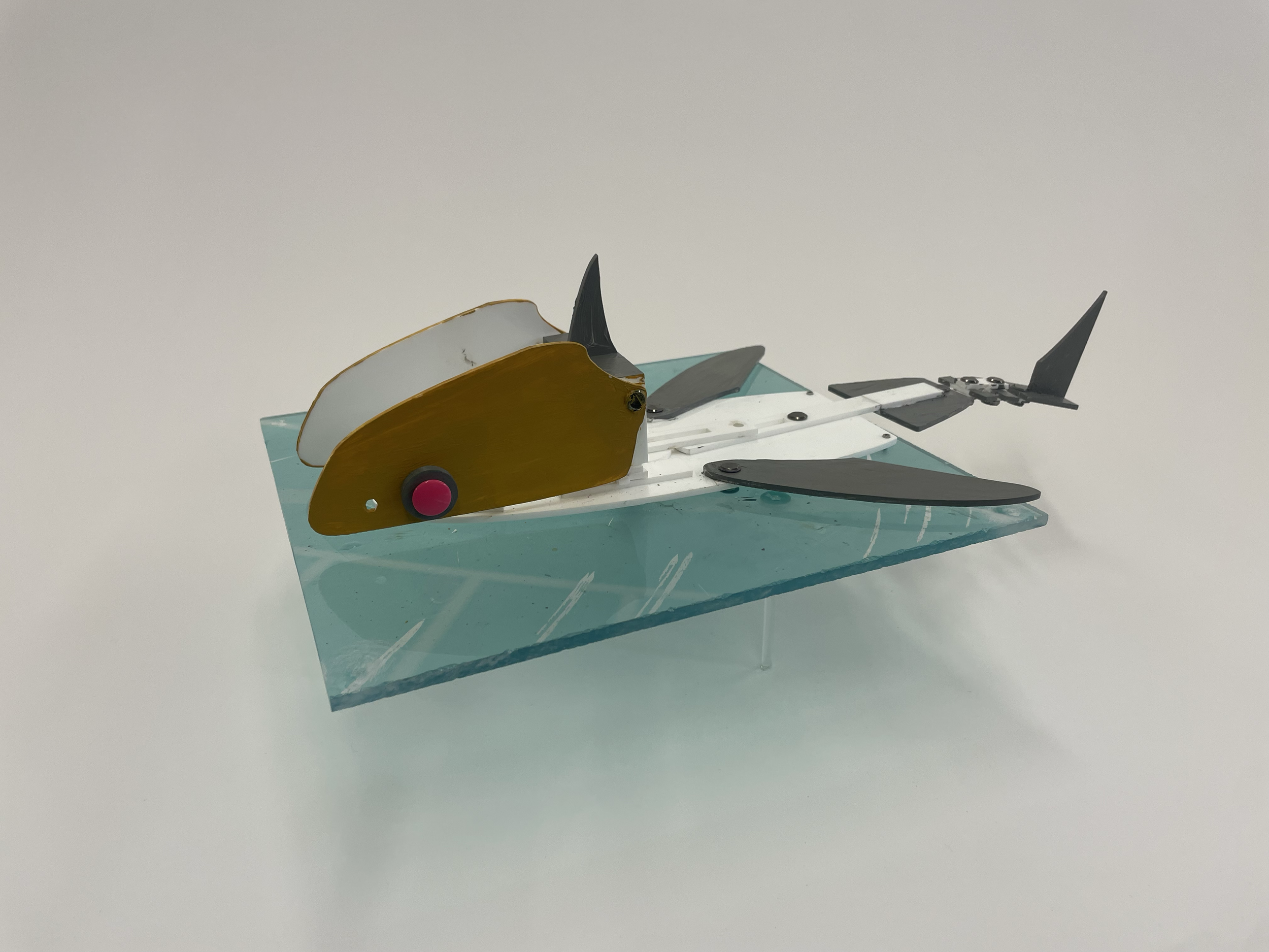 A laser-cut acrylic breadboard mockup made after the paper mockup; while it was fully functional and the mechanism itself was resilient, the tail was reinforced with chicago screws which rapidly lost strength as it worked
