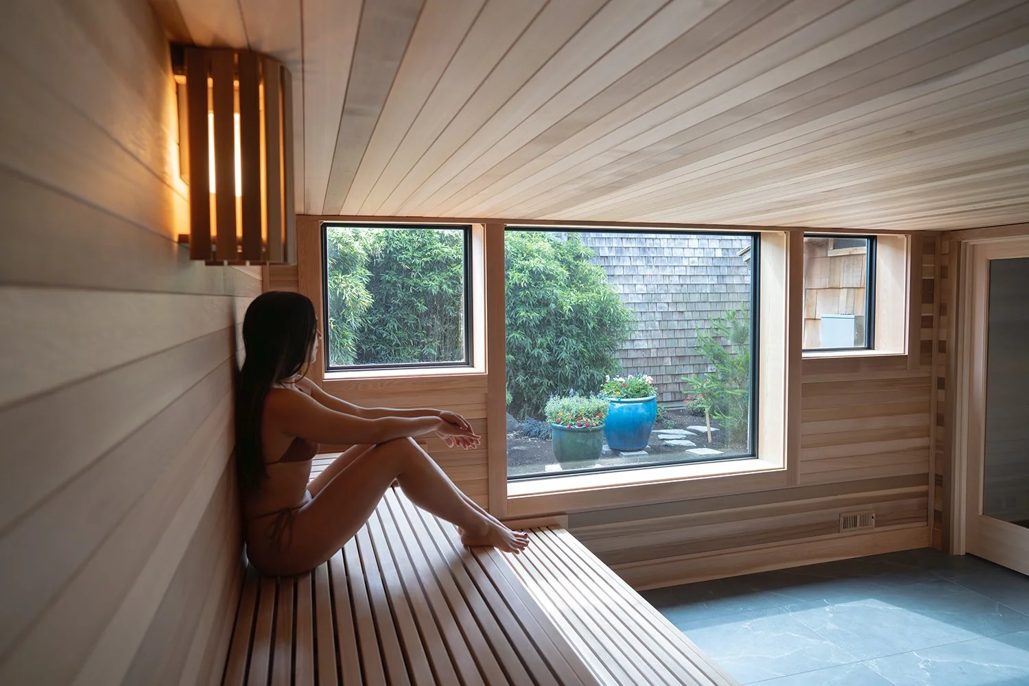 woman relaxing in dry cedar sauna at Loma Sauna House Oregon coast wellness retreat