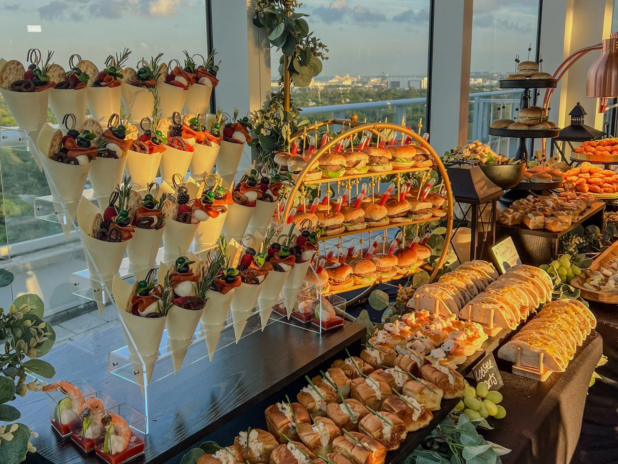 Upscale Miami high-rise event catering display with gourmet sliders, appetizer cones and elegant cocktail hour presentation.