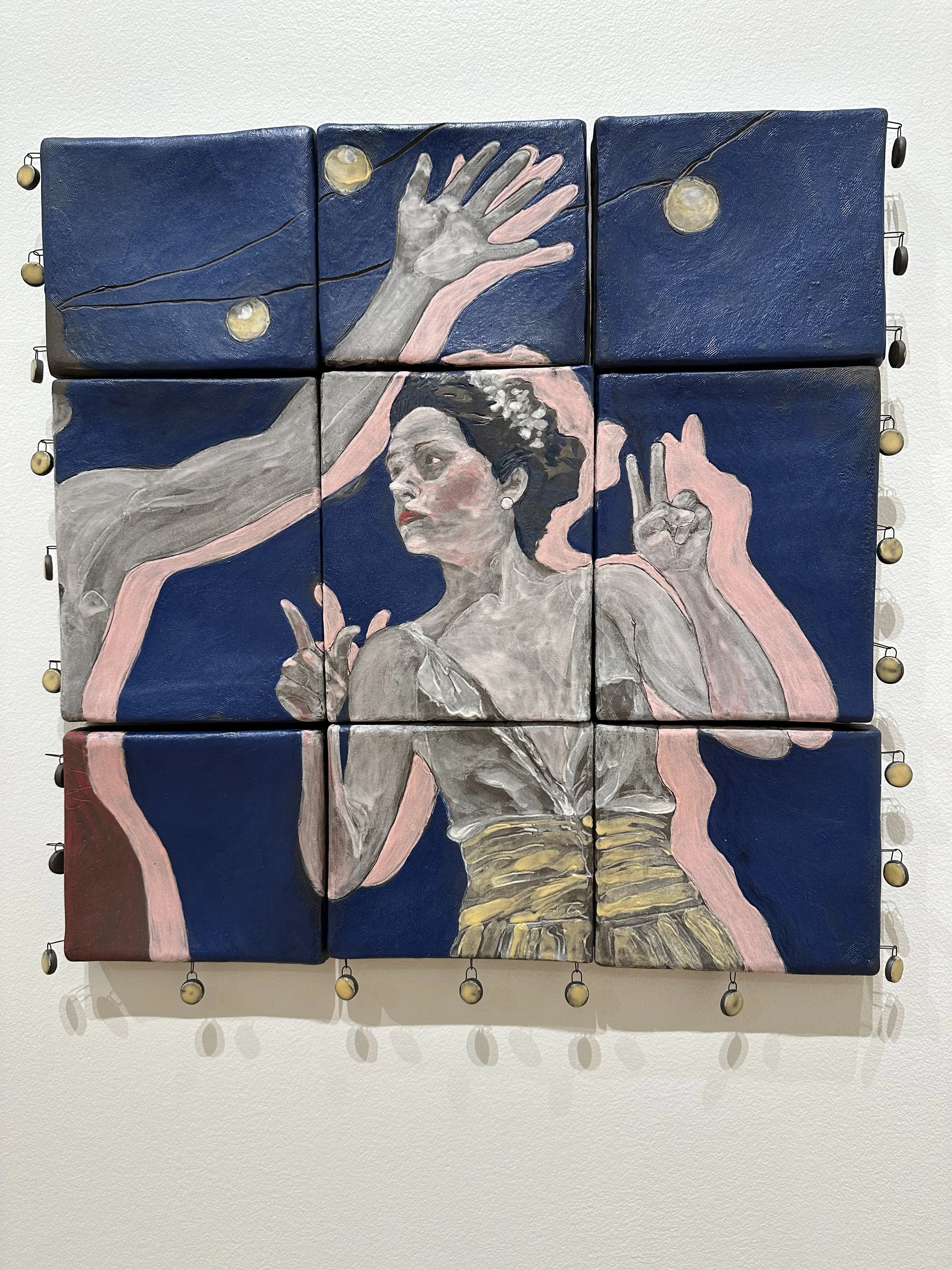 Painting of a woman dressed in traditional attire, with arms raised in a dance pose, surrounded by string lights, shown on a 3x3 grid of canvases.