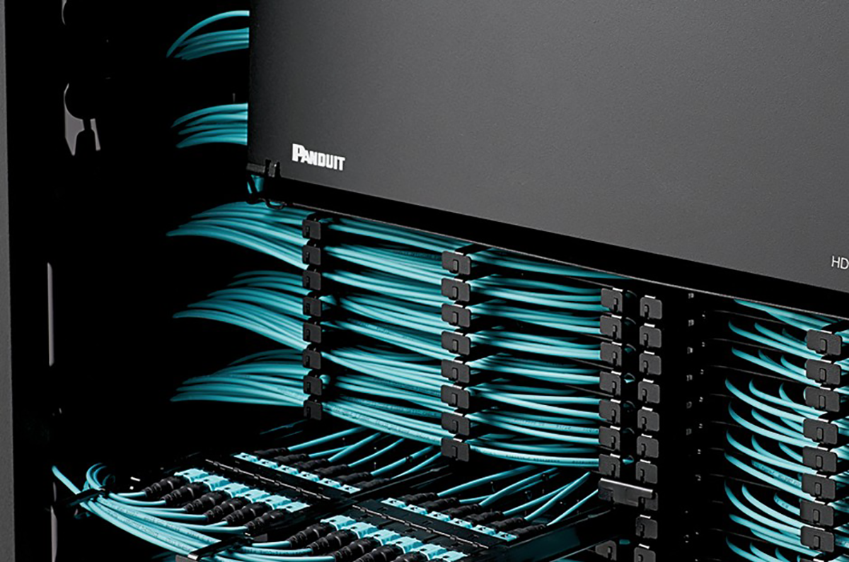 Close-up of a black server rack with multiple blue Ethernet cables organized and connected to networking hardware.