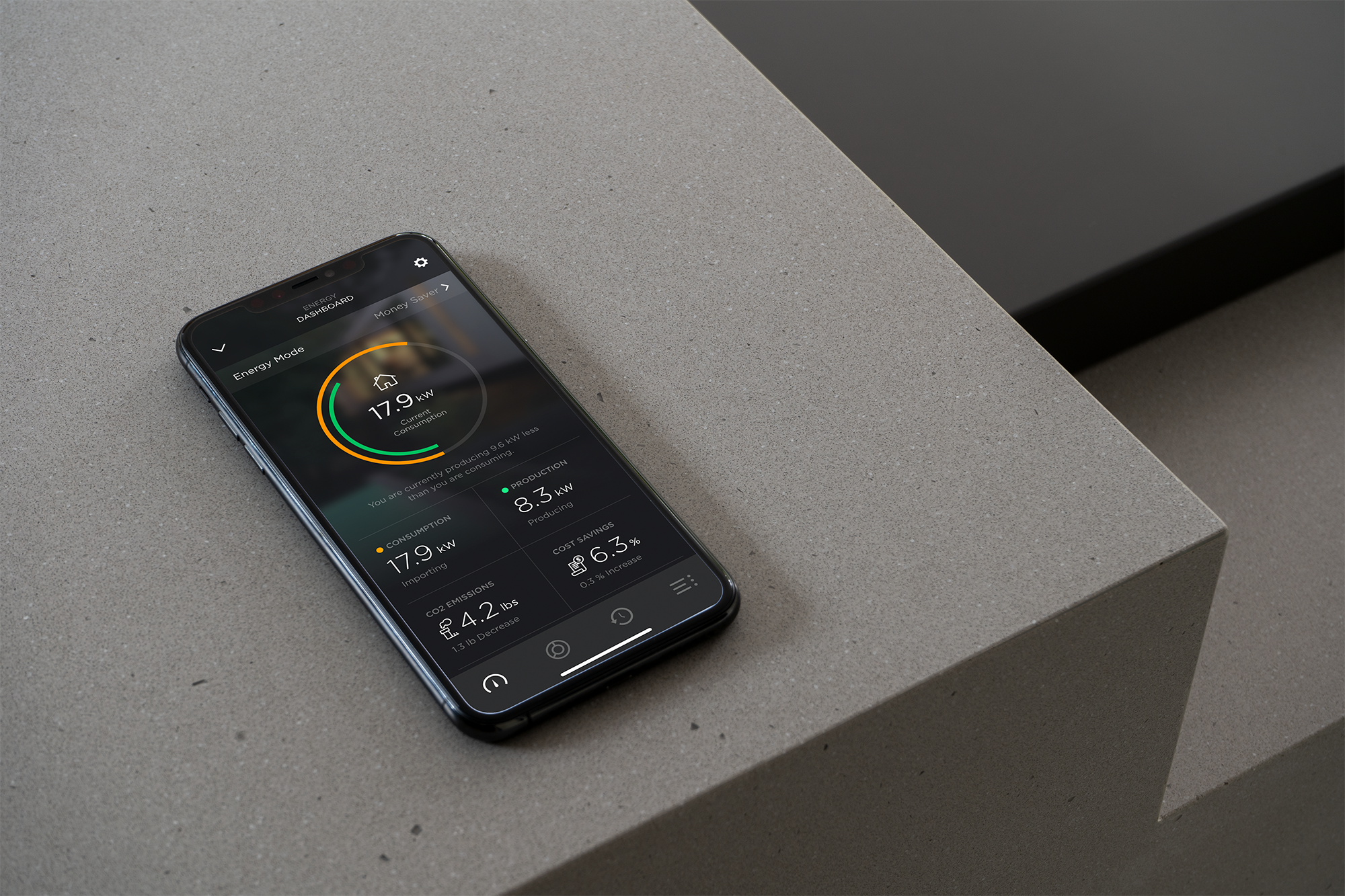 Smartphone displaying energy consumption data on a gray surface.
