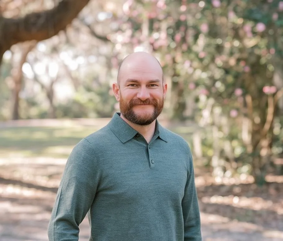 A man smiling in a business shirt.