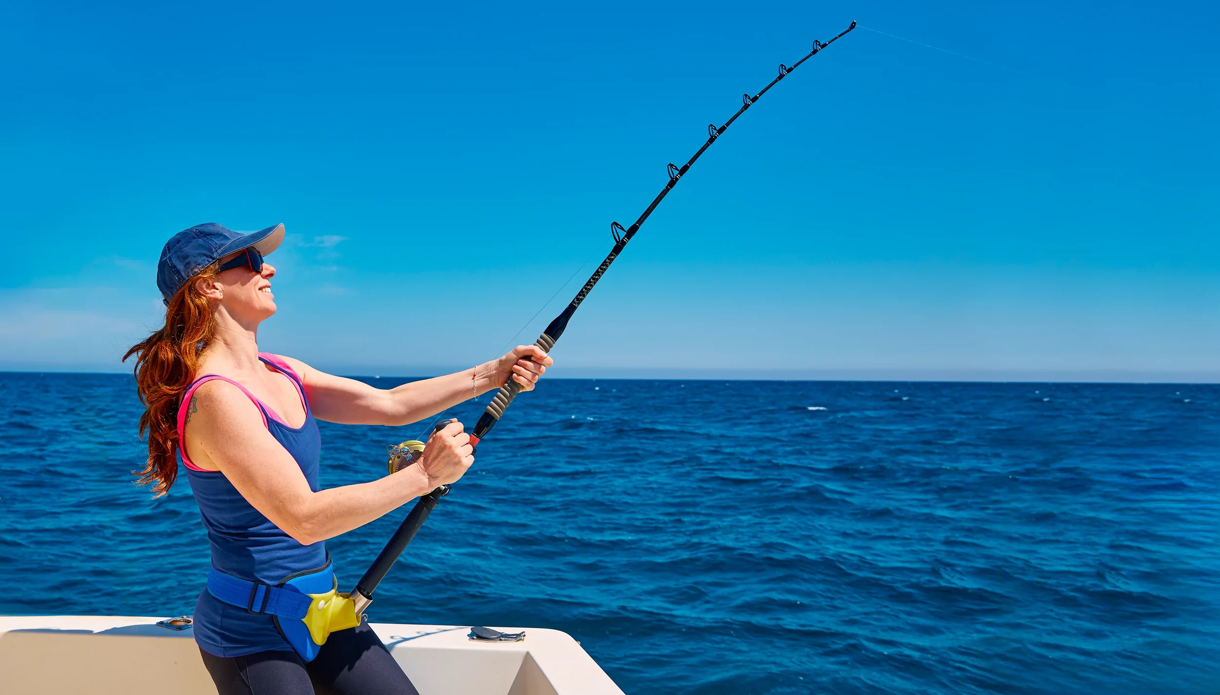 Mujer pescando a bordo de un barco en Dénia durante un chárter de pesca.