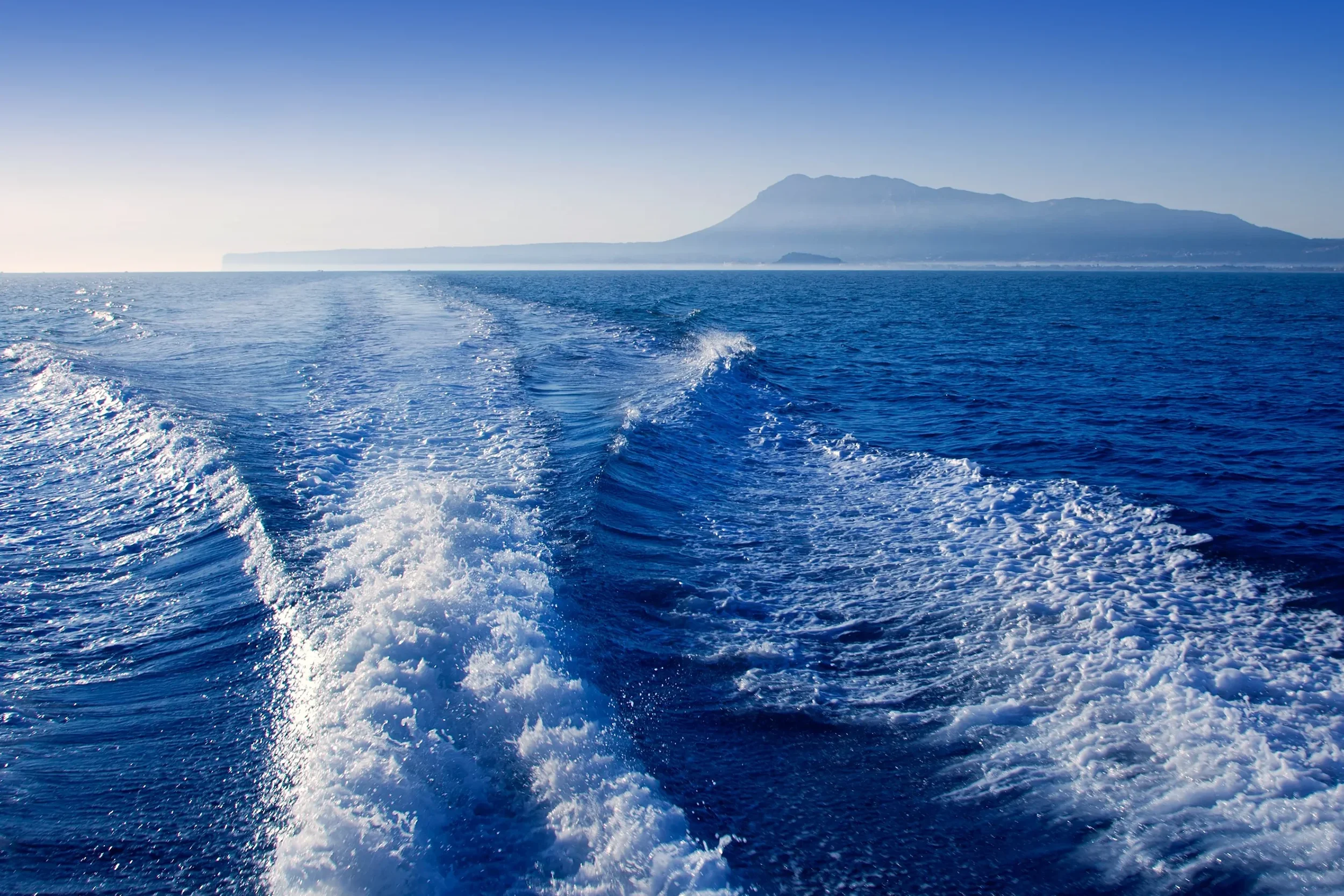 Estela de barco en el mar Mediterráneo con la costa de Dénia, Les Rotes y el Montgó al fondo