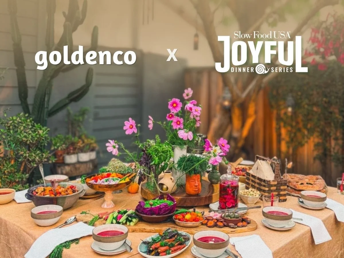goldenco x Slow Food USA Joyful Dinner Series: a garden table in Los Angeles set with borscht, stonefruit panzanella, crudite, olive fougasse, bread and cosmos flowers for a summer solstice dinner.