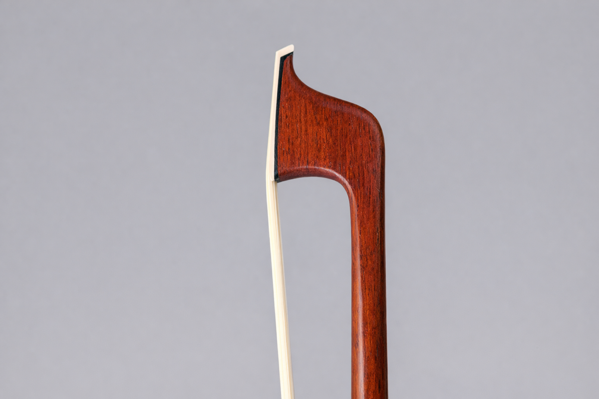 Close-up of a violin bow against a gray background.
