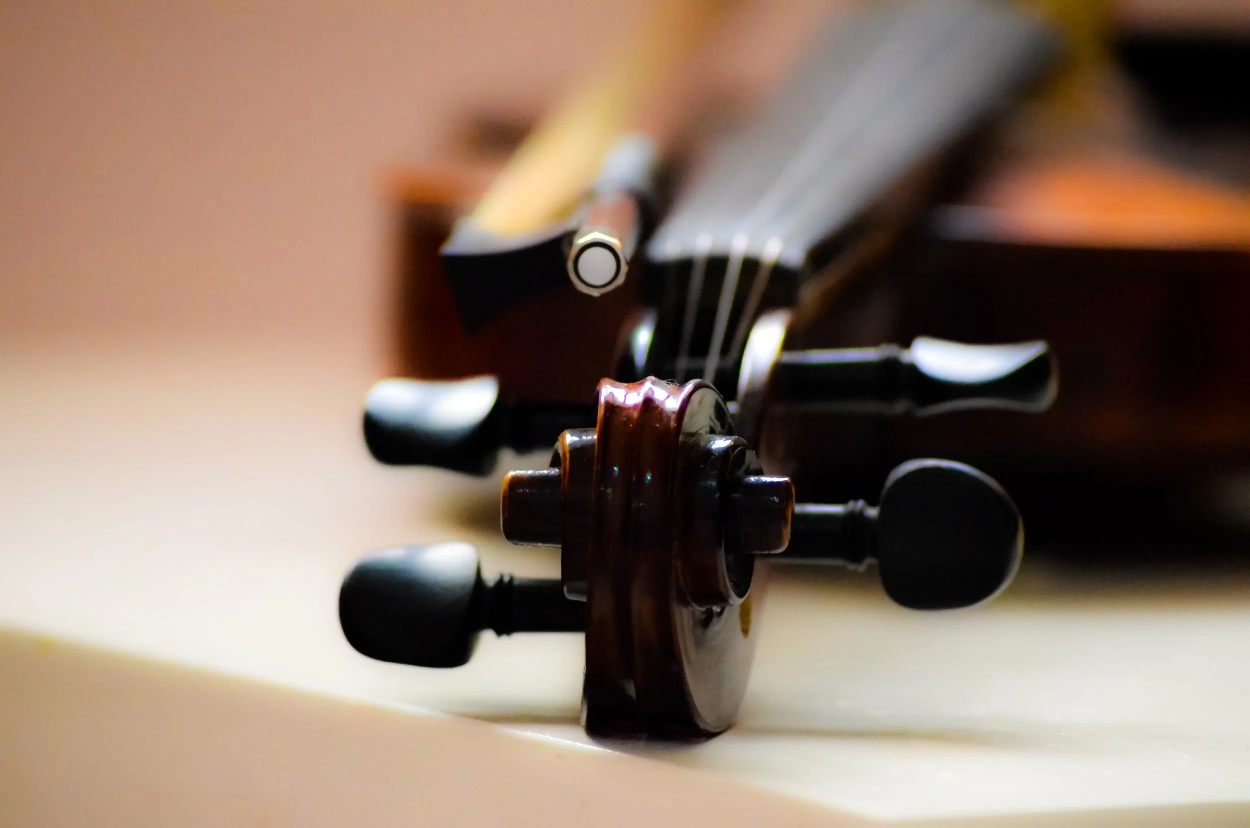 Close-up of the scroll and tuning pegs of an acoustic guitar lying on a surface.