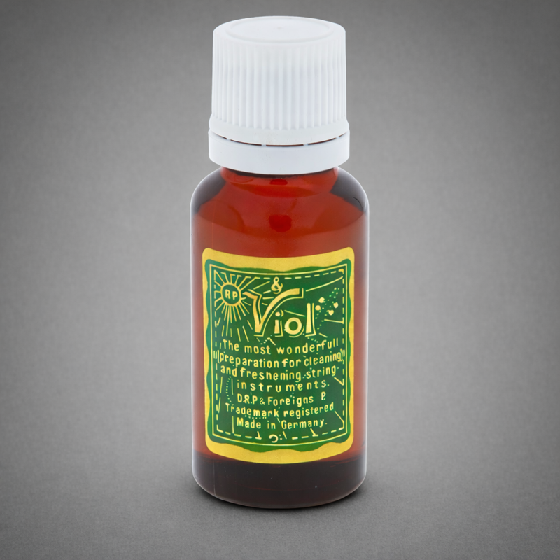 A small amber glass bottle with a white screw cap, featuring a green and yellow label that reads "RP & Viol: the most wonderful preparation for cleaning and refreshing string instruments. D.R.P. & Foreign P. Trademark registered. Made in Germany."