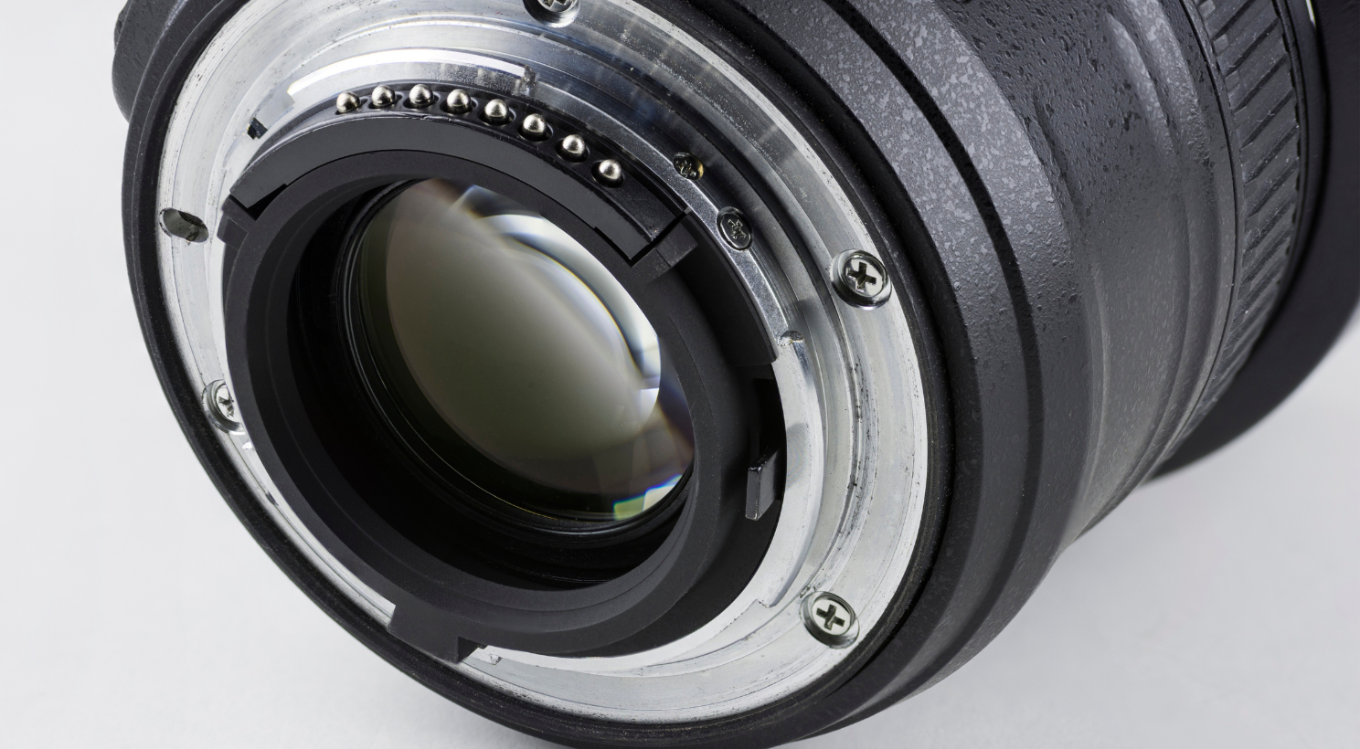 Close-up of a camera lens showing the rear mount and electronic contacts.