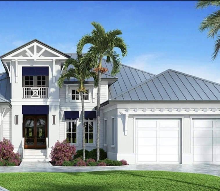 A modern white house with a grey metal roof, a front door with glass panels, and a large garage. Palm trees and pink bushes are in the front yard under a blue sky.