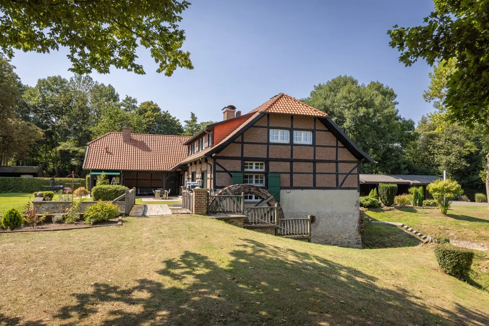 Empty living room with large window, white walls, and wooden flooring.