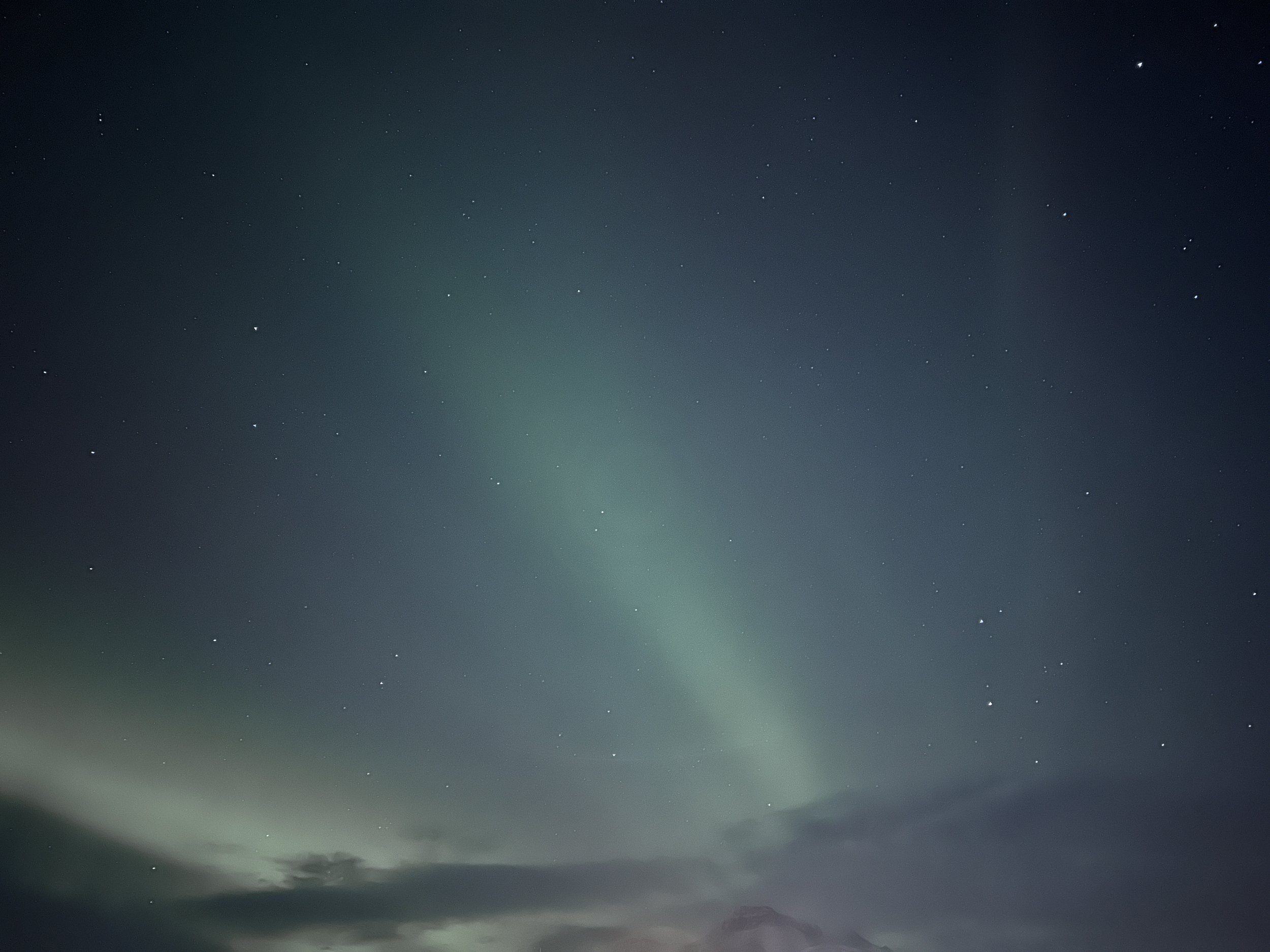 Night sky with visible stars and the aurora borealis.