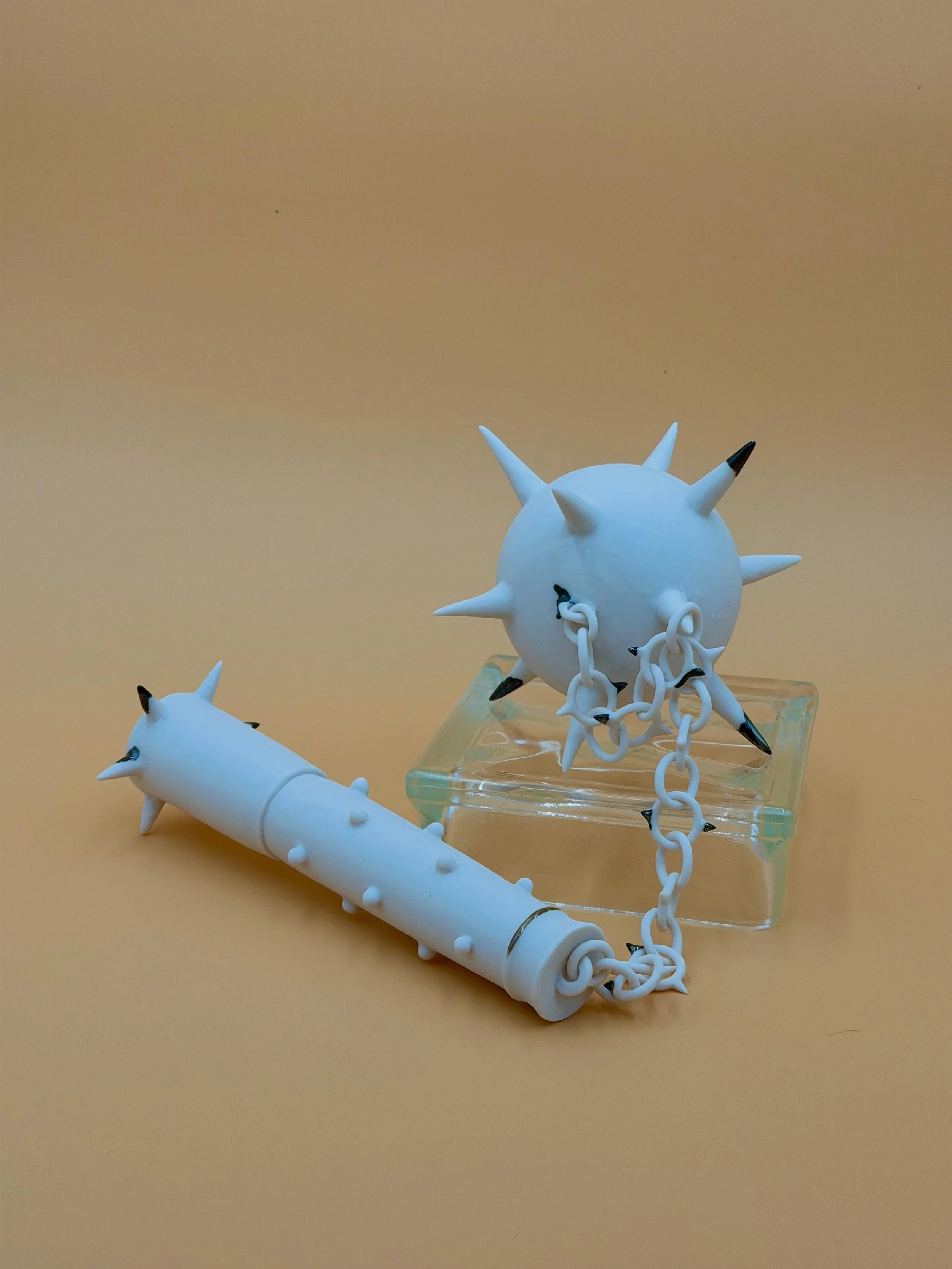 porcelain flail (single-use)

two wheel-thrown hollow forms connected by a spiked chain. the chain fully support the weight of the striking head when it hangs!