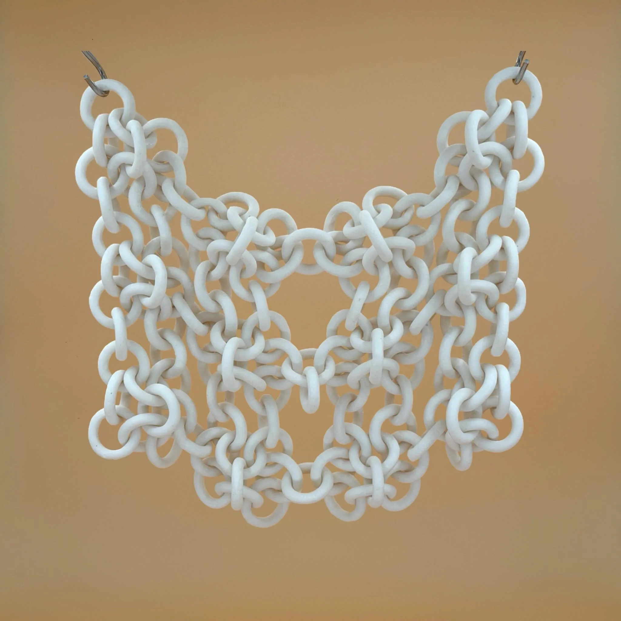 chainmail, revisited.

the advantage of working with unglazed modular chains is that i can add on rings at any part of the process&mdash; including after firing to vitrification! i decided i wanted the panel to be completely symmetrical, so here's th