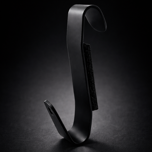 A black, curved object with an adhesive strip on one side, set against a dark background.