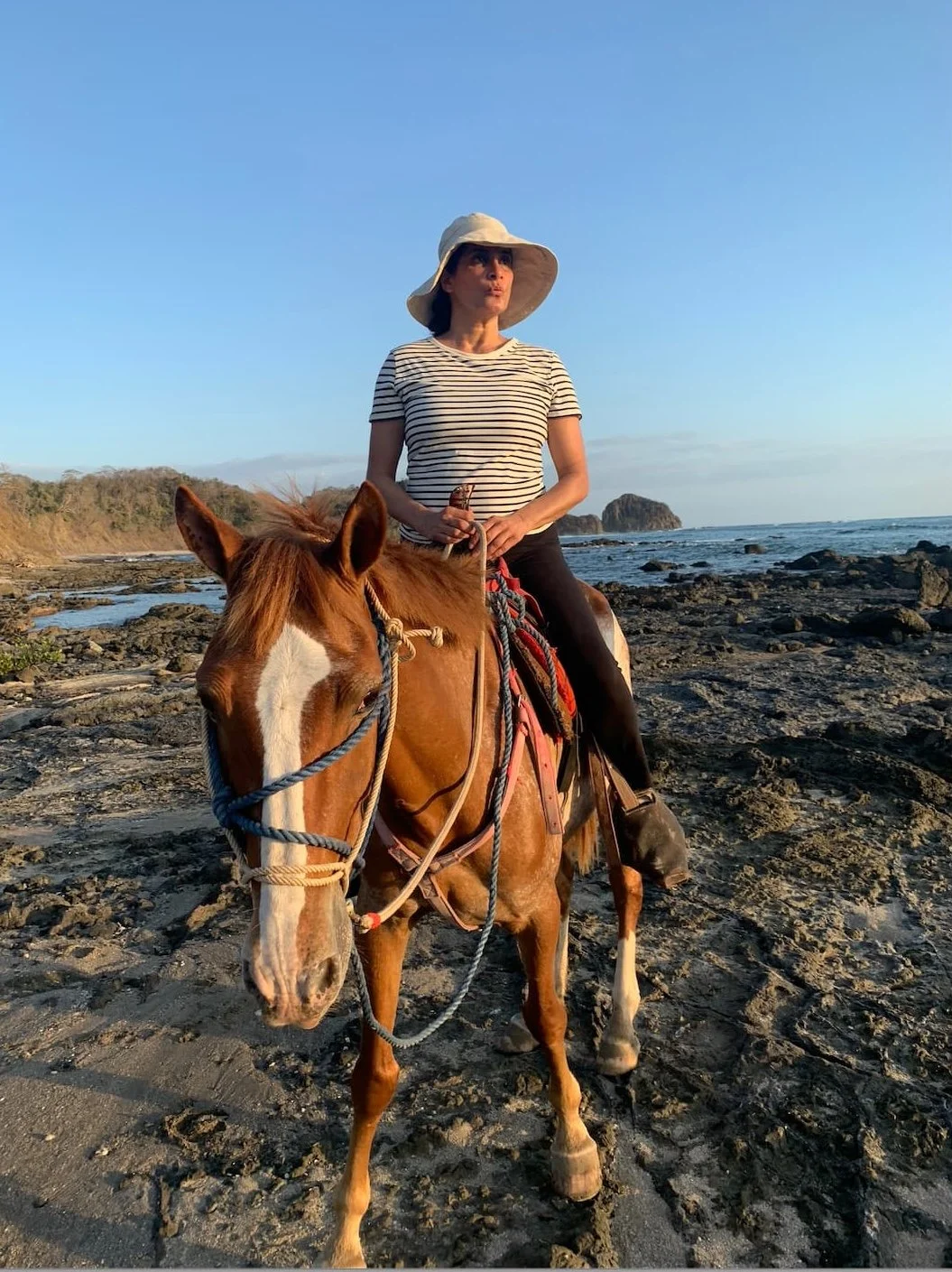 Anjali Augustine horseback riding along the beach at sunset in Nosara, Costa Rica.