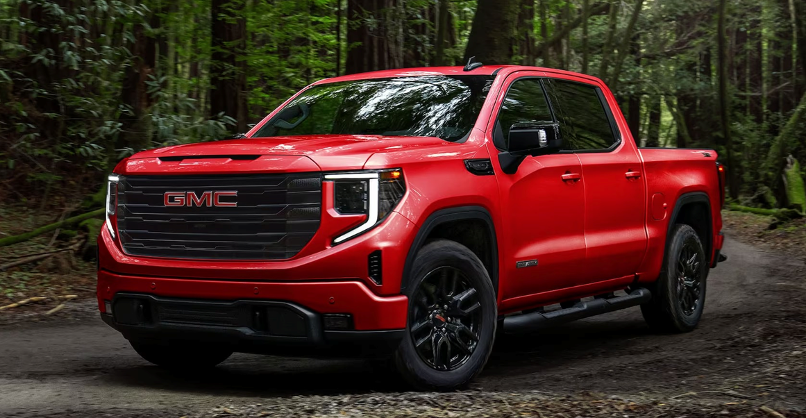 Red GMC pickup truck driving on a dirt road in a forested area near Okanagan Lake and Vernon BC. Four door crew cab, clean and new looking, well maintain and ready to be driven.  TK Glamping and Wellness in Vernon BC.