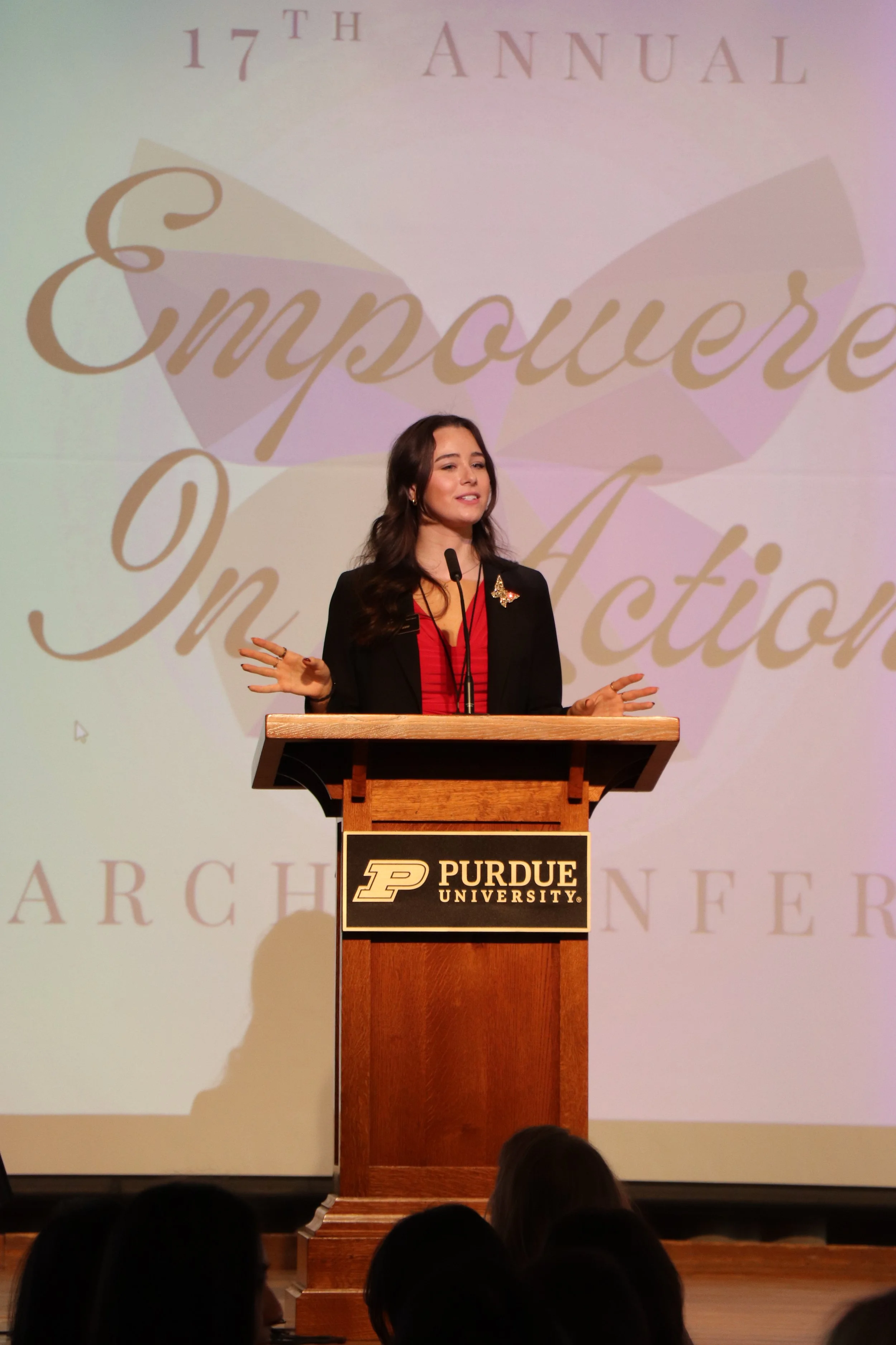 A woman giving a speech at a podium at Purdue University during the 17th Annual Empowere in Action conference.