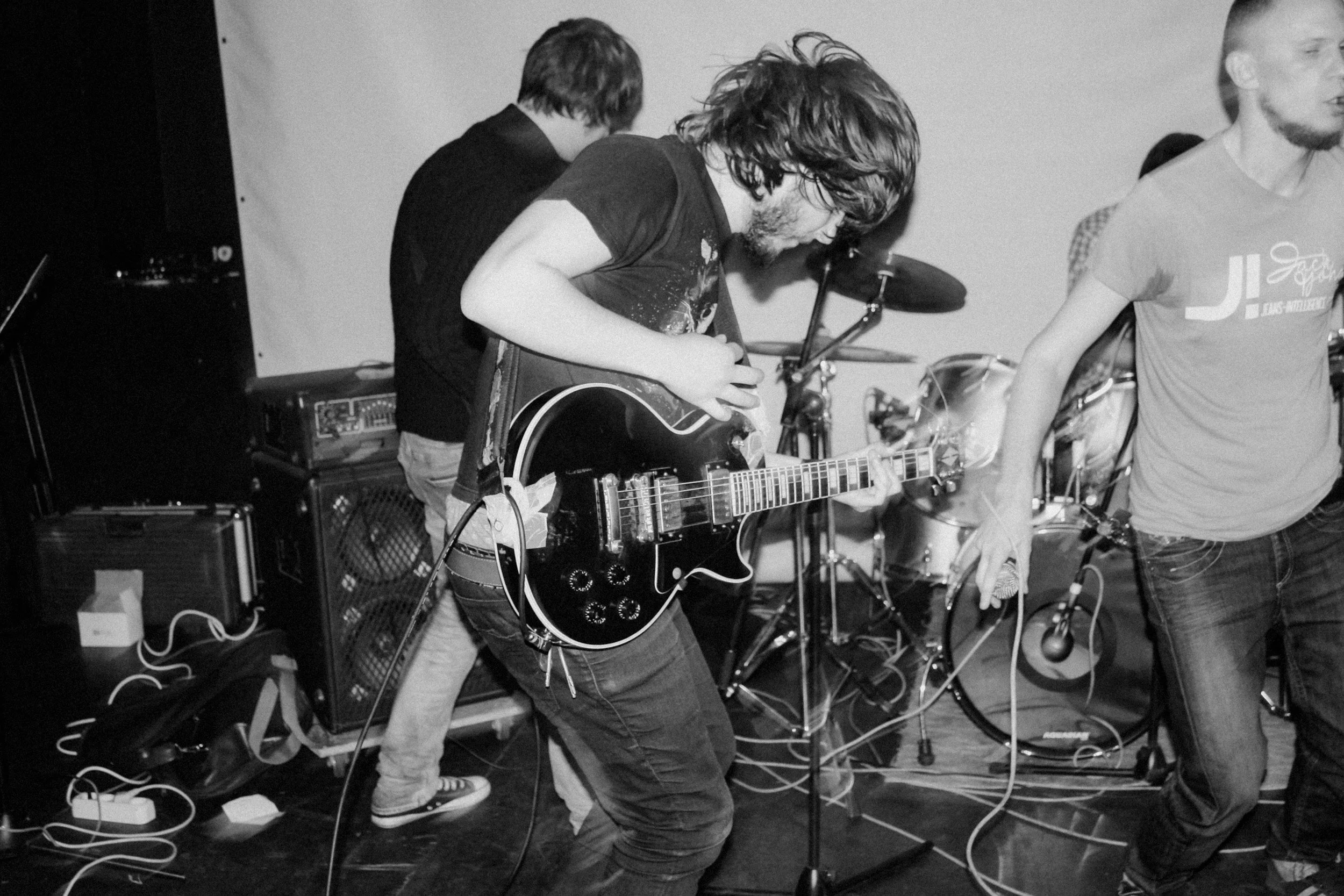 black and white photo of musician playing guitar in a band