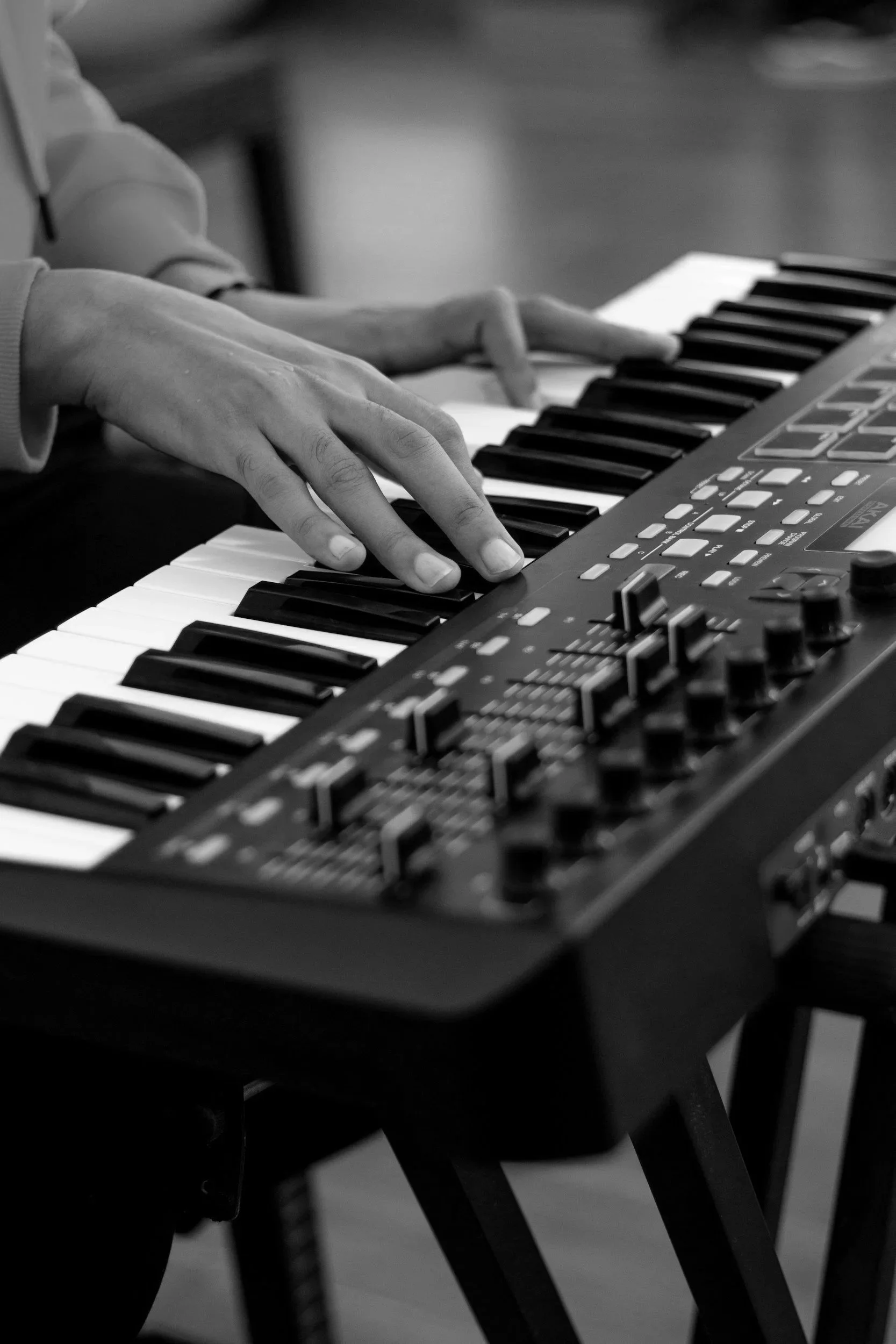 Person playing a keyboard synthesizer.