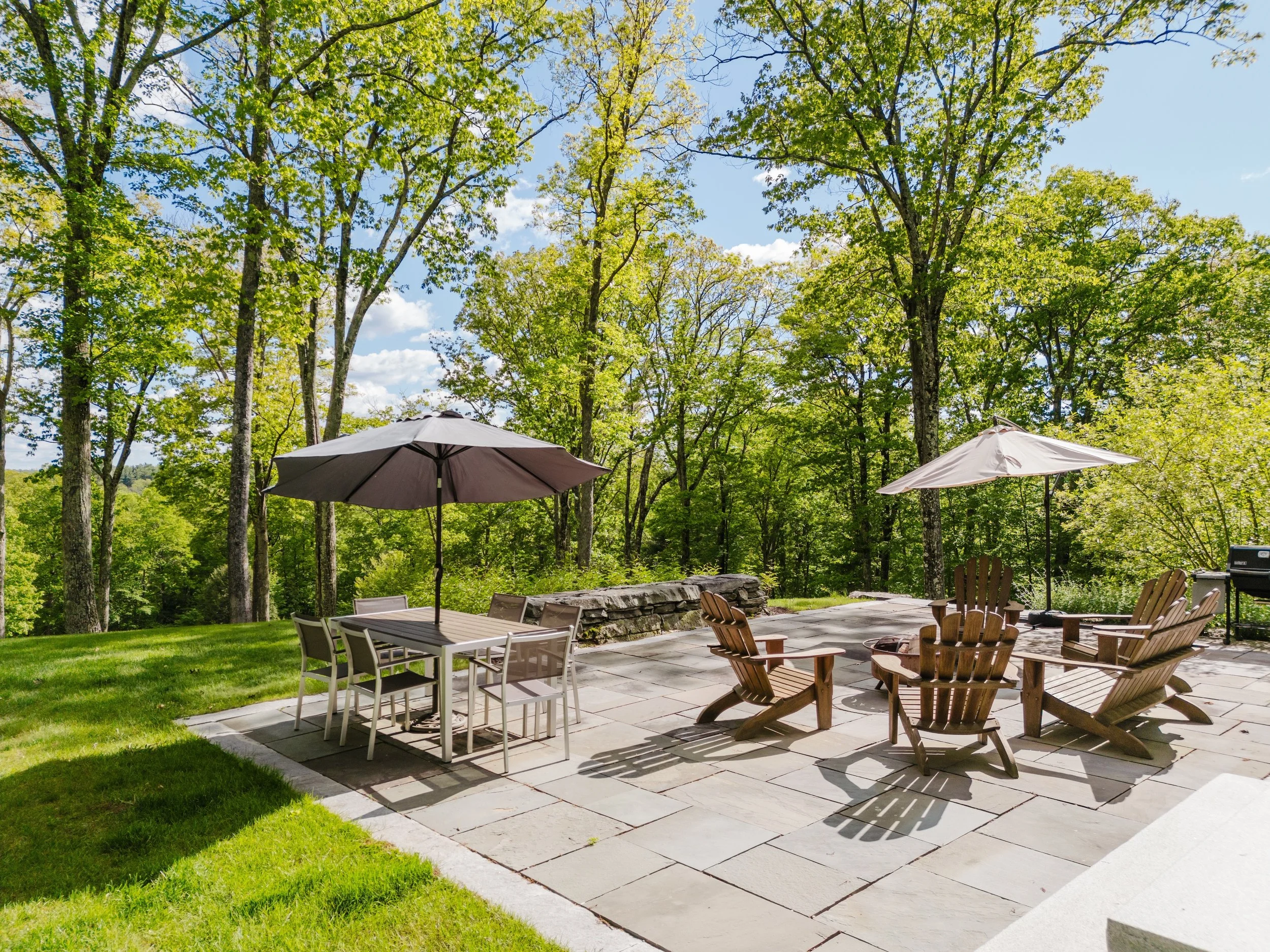 Private stone patio with grill, dining, and firepit