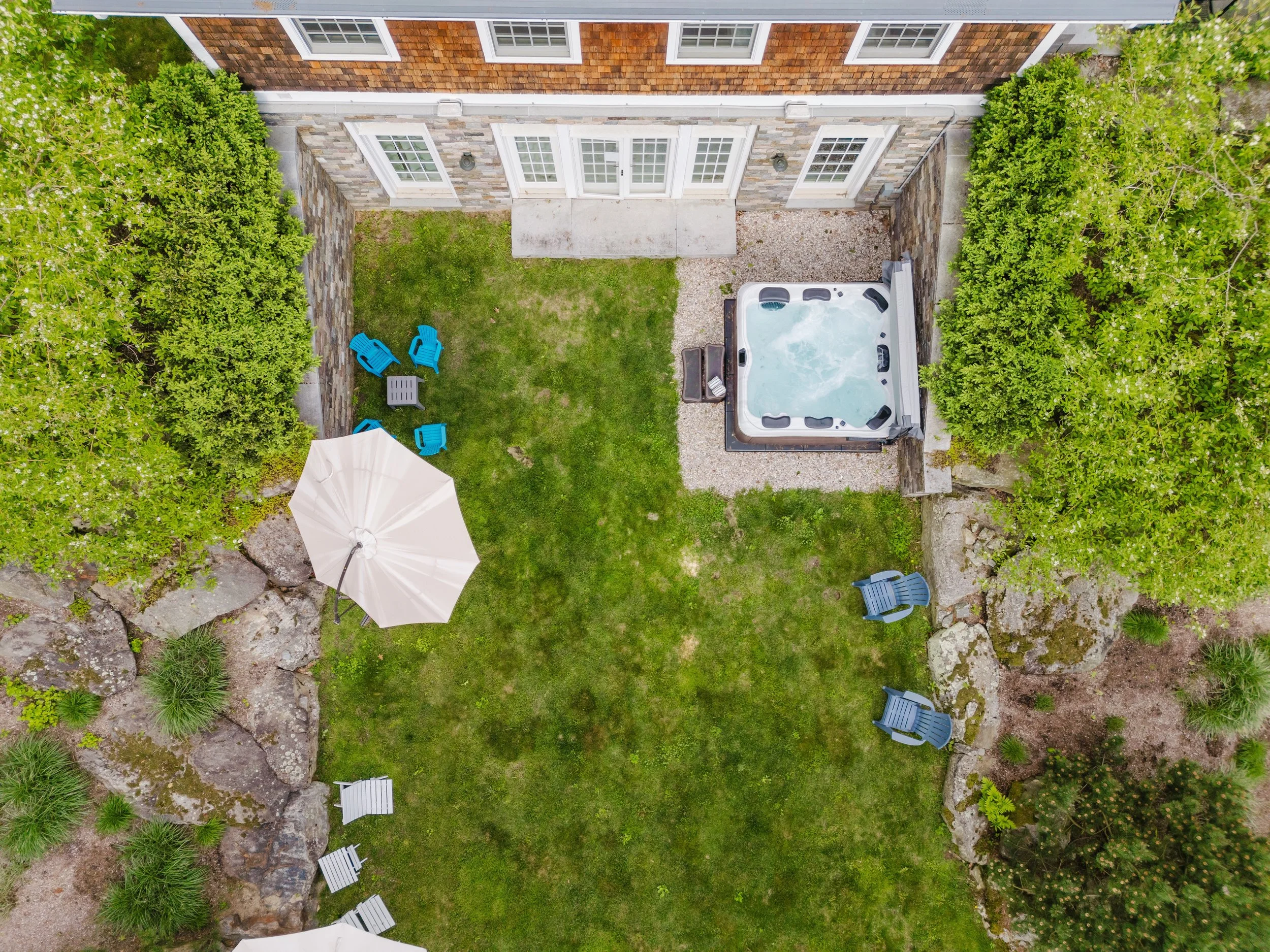 Aerial of backyard with hot tub and lounge chairs