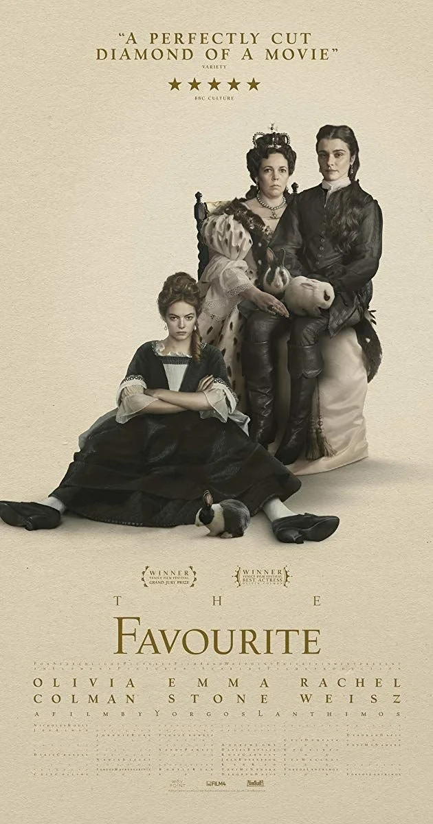 Promotional poster for the movie "The Favourite" featuring three women in period costumes, one seated on the ground with arms crossed, one standing with a crown, and one sitting on a chair holding a puppet, with awards and critics' quotes at the top and title at the bottom.