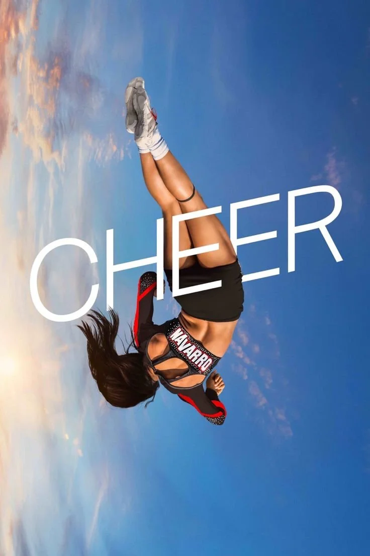 A woman in athletic gear performing a handstand in the sky with clouds and blue sky in the background. The word "CHEER" is written across the image.