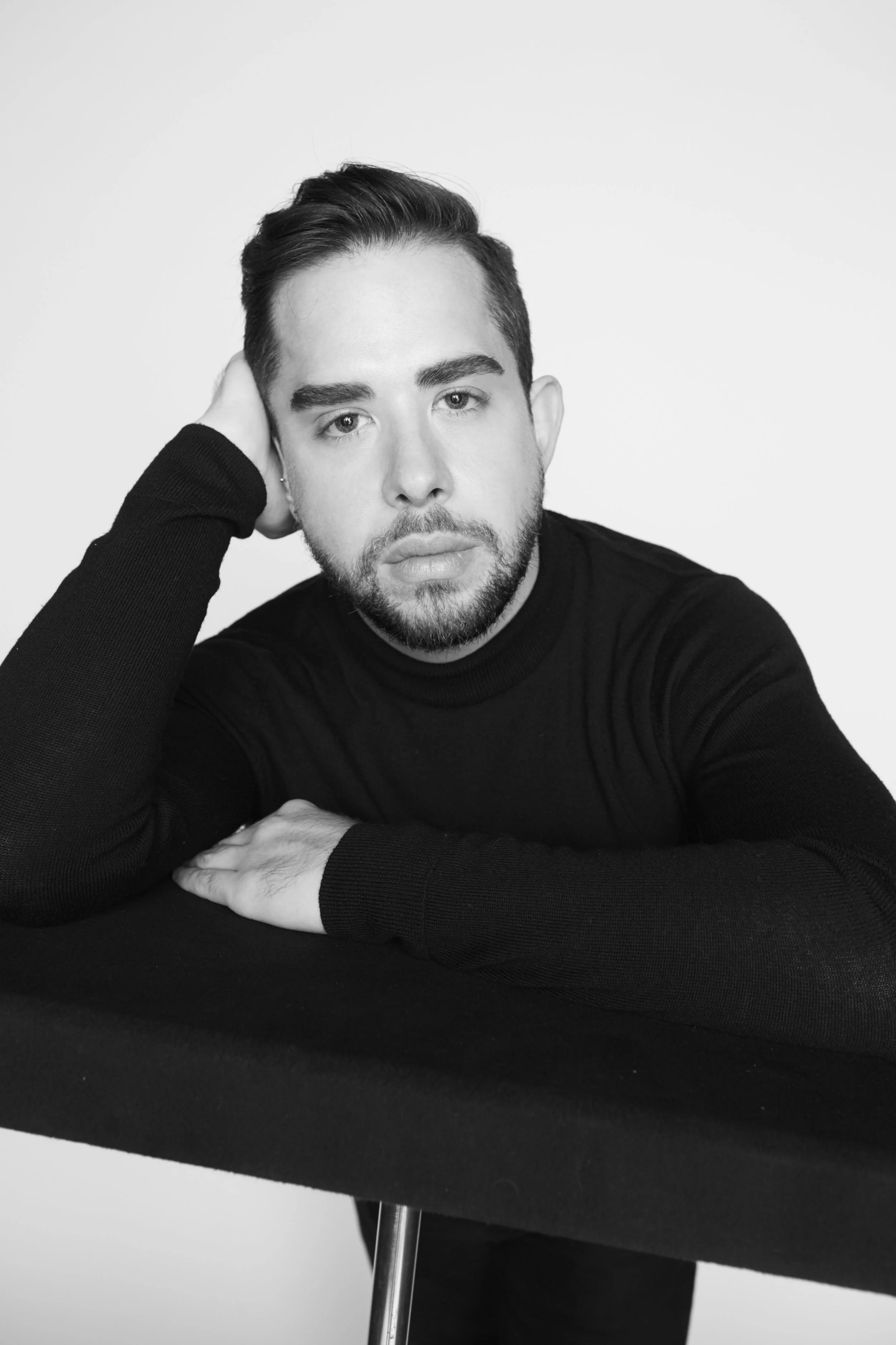 Editor Adam Mansuroglu posing on black stand on set of a photoshoot for his portfolio on adammansuroglu.com