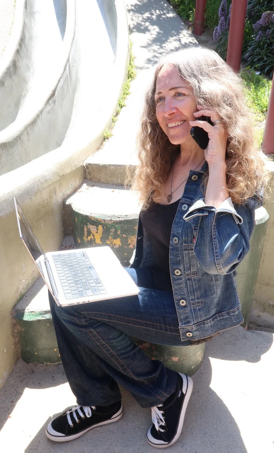 Tommi on her phone with her laptop