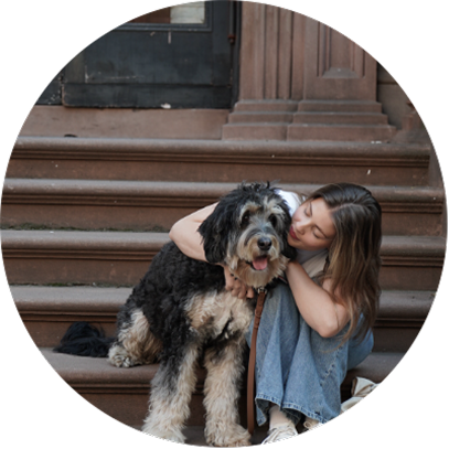 Happiness your way; Fluffy dog with young woman hugging the dog while sitting on steps. Pets are great companions and help us feel happier.
