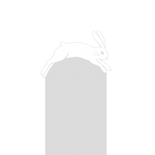 A white rabbit lying on top of a gray cylinder